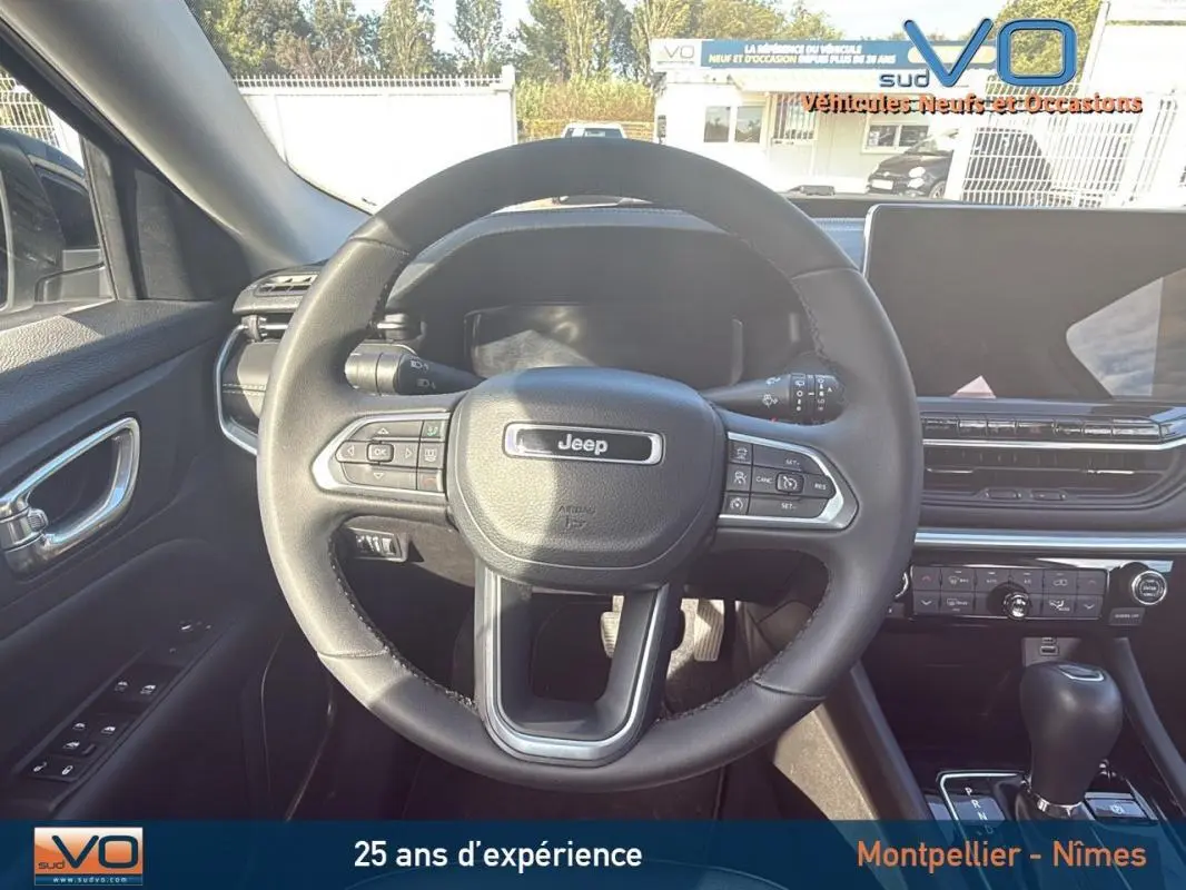 Vue centrée sur le volant du Jeep Compass 2024, montrant le tableau de bord et la console avec écran tactile.