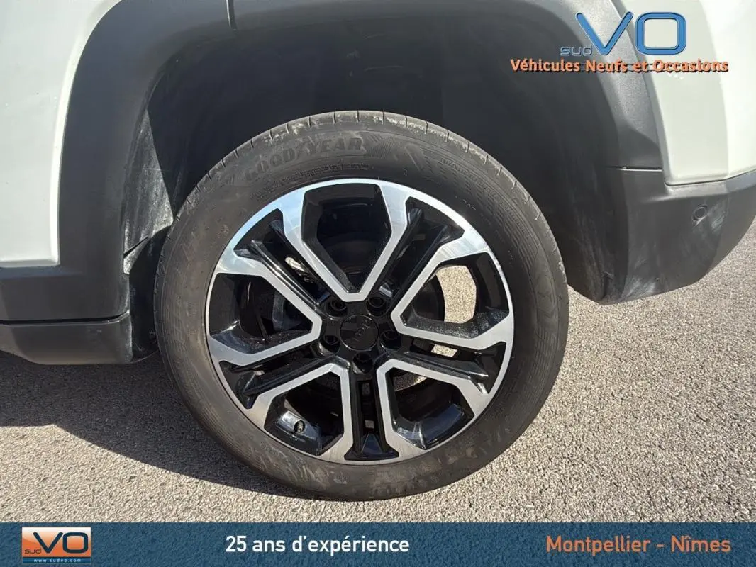 Gros plan sur la roue avant gauche du Jeep Compass blanc 2024 avec jante alliage 18 pouces au design moderne.