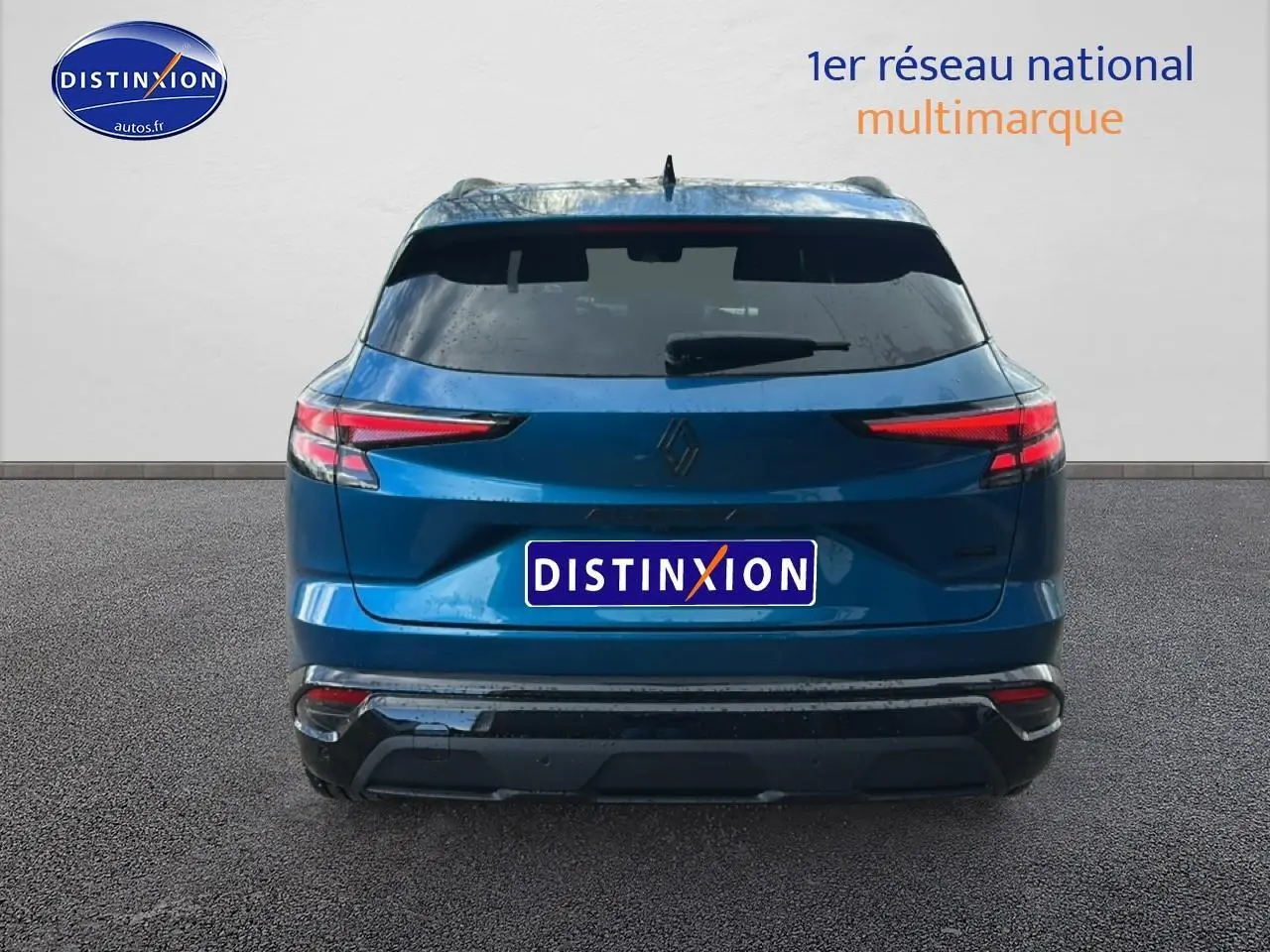 Vue arrière d'un Renault Austral bleu 2026 avec feux LED et barres de toit visibles sur fond neutre.