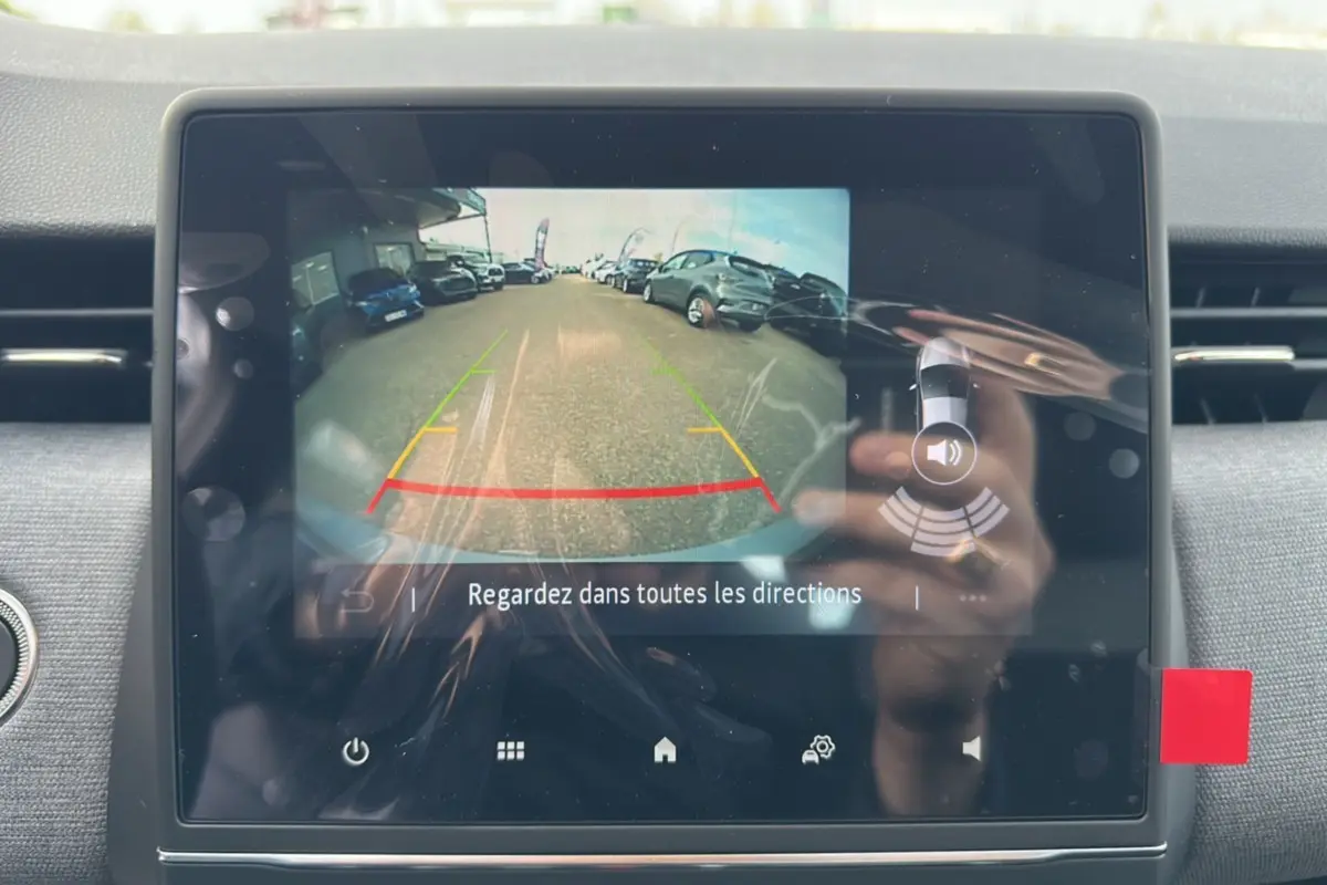 Écran tactile intérieur montrant la caméra de recul de la Renault Clio DCI 100 Evolution en marche.