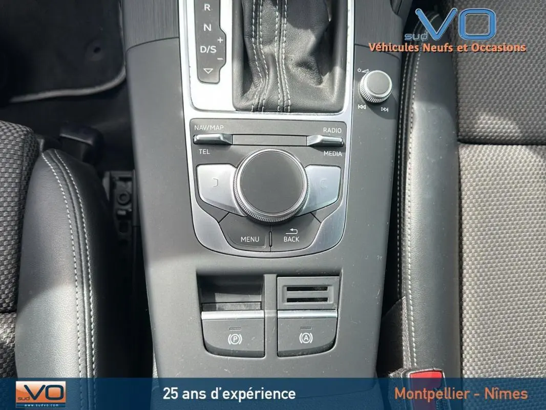 Vue rapprochée de la console centrale grise de l'Audi A3 Sportback 2018 avec levier de vitesses et accoudoir en cuir noir.