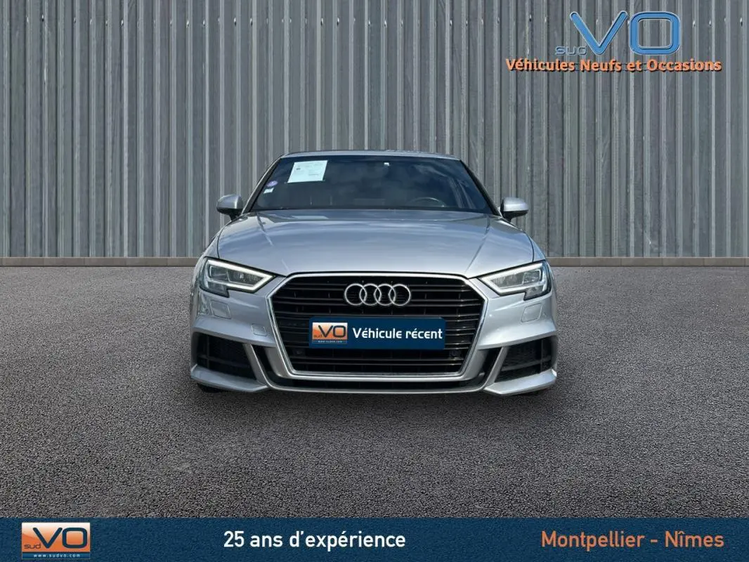 Vue frontale d'une Audi A3 Sportback gris clair 2018 avec calandre noire et phares LED distinctifs.