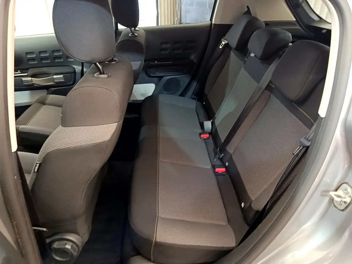 Vue intérieure côté droit montrant la banquette arrière grise et noire du Citroën C3 PureTech 2019 avec détails de couture jaune.