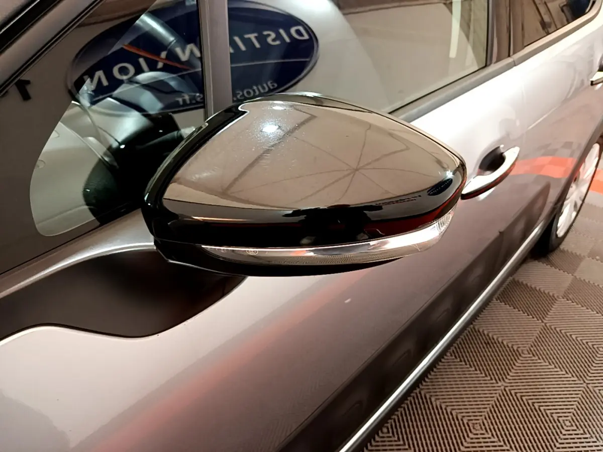 Rétroviseur noir brillant côté gauche d'une Citroën C3 gris clair 2019, avec poignée de porte visible en arrière-plan.