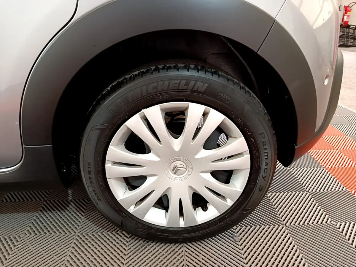 Gros plan sur la roue avant droite grise claire d'une Citroën C3 2019 avec enjoliveur blanc et pneu Michelin.