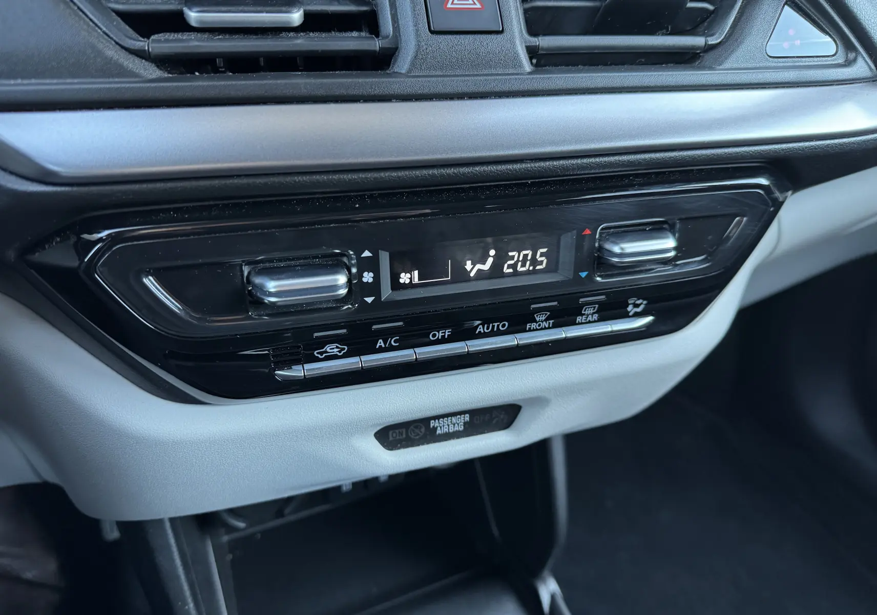 Gros plan sur la console centrale de la Suzuki Swift 2024, affichant la climatisation automatique à 20,5°C avec commandes tactiles noires et grises.