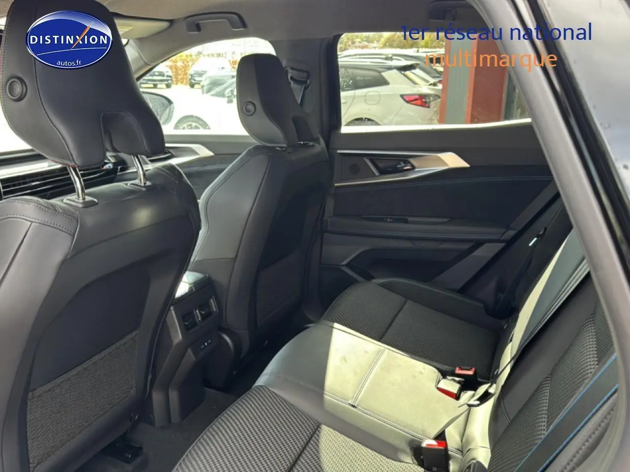 Vue intérieure arrière côté droit du Renault Austral noir avec sièges en Alcantara et surpiqûres bleues.