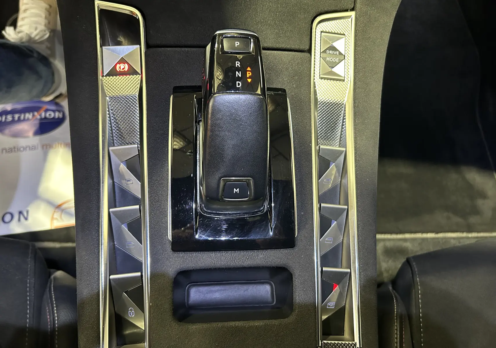 Gros plan sur la console centrale noire du DS7 2024 avec levier de vitesses automatique et boutons triangulaires argentés.