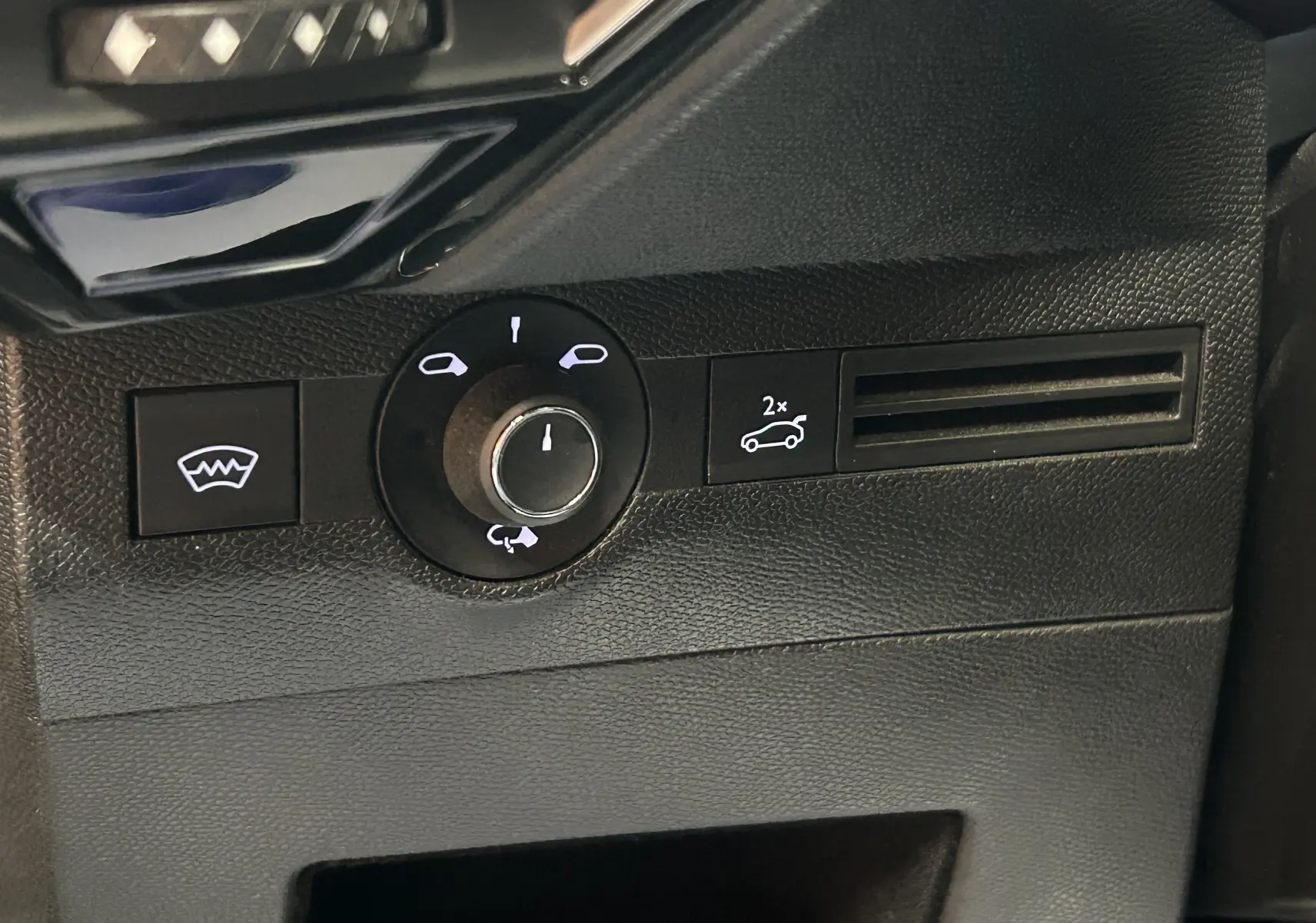 Gros plan sur le panneau de commandes côté conducteur du DS7 gris titane, avec bouton de réglage des rétroviseurs et ouverture du hayon électrique.