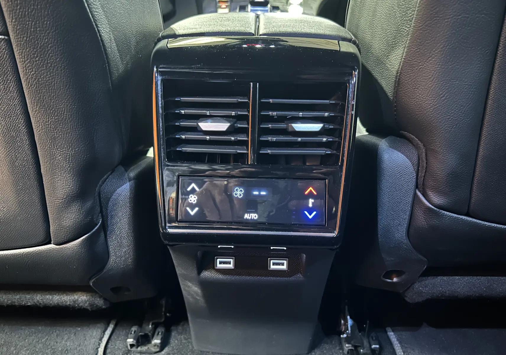 Vue rapprochée de la console arrière avec commandes de climatisation et ports USB du DS7 gris titane 2024.