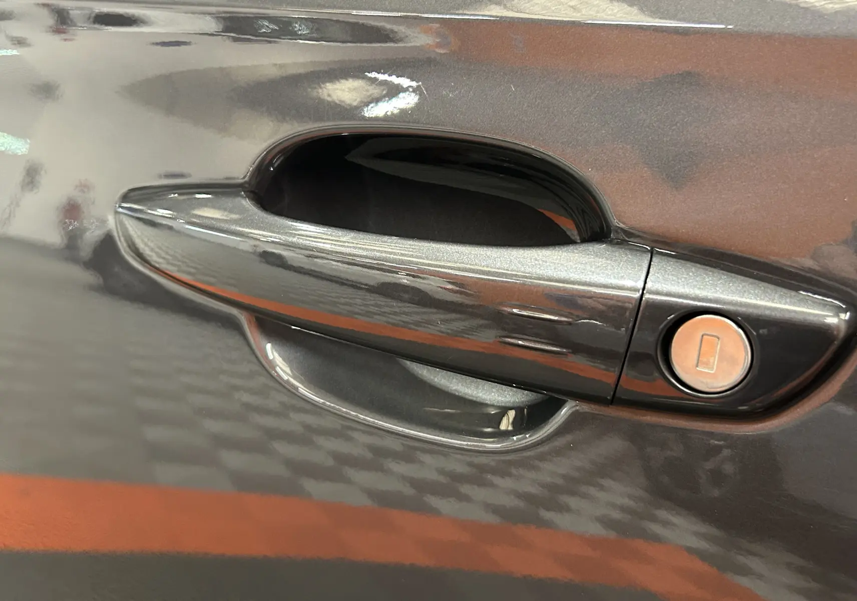 Poignée de porte gris titane du DS7 2024 en gros plan, avec serrure intégrée sur la partie droite.