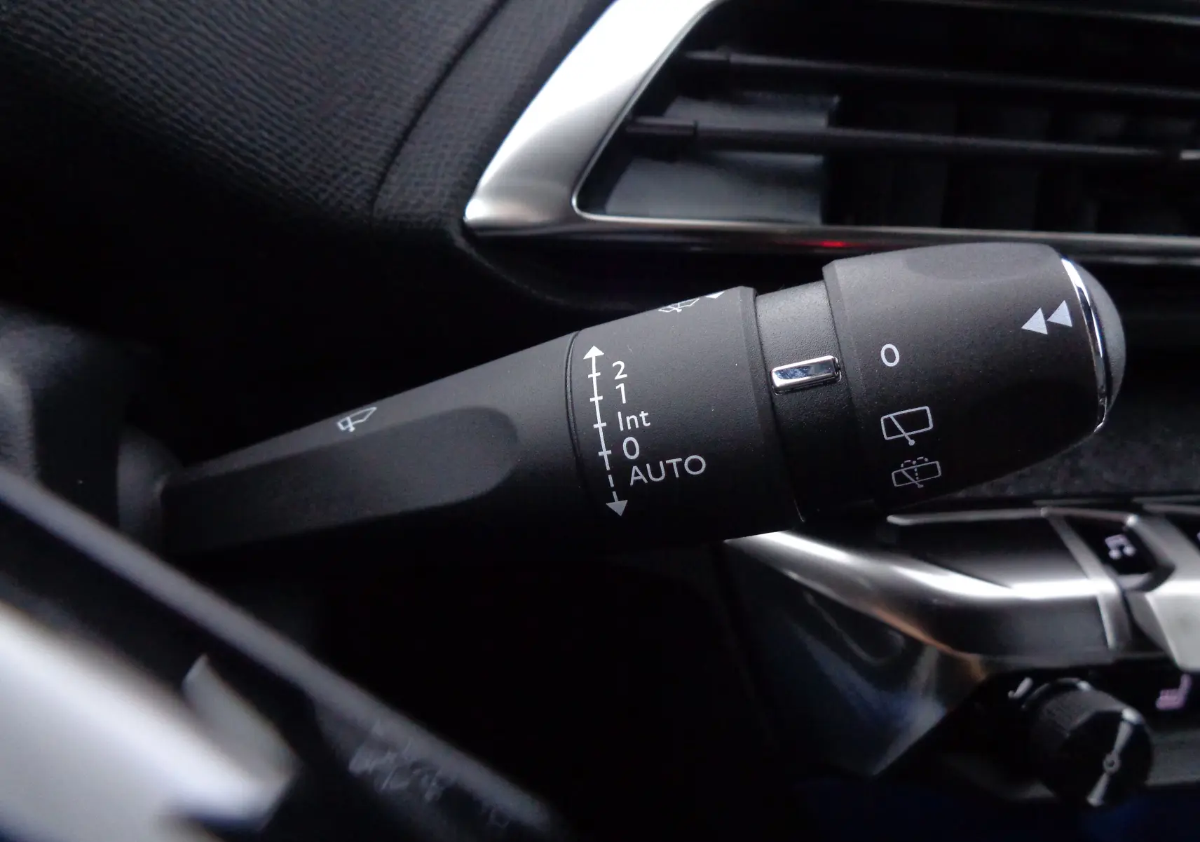 Gros plan sur la commande d'essuie-glace à gauche du volant dans l'habitacle du Peugeot 3008 bleu Celebes 2023.