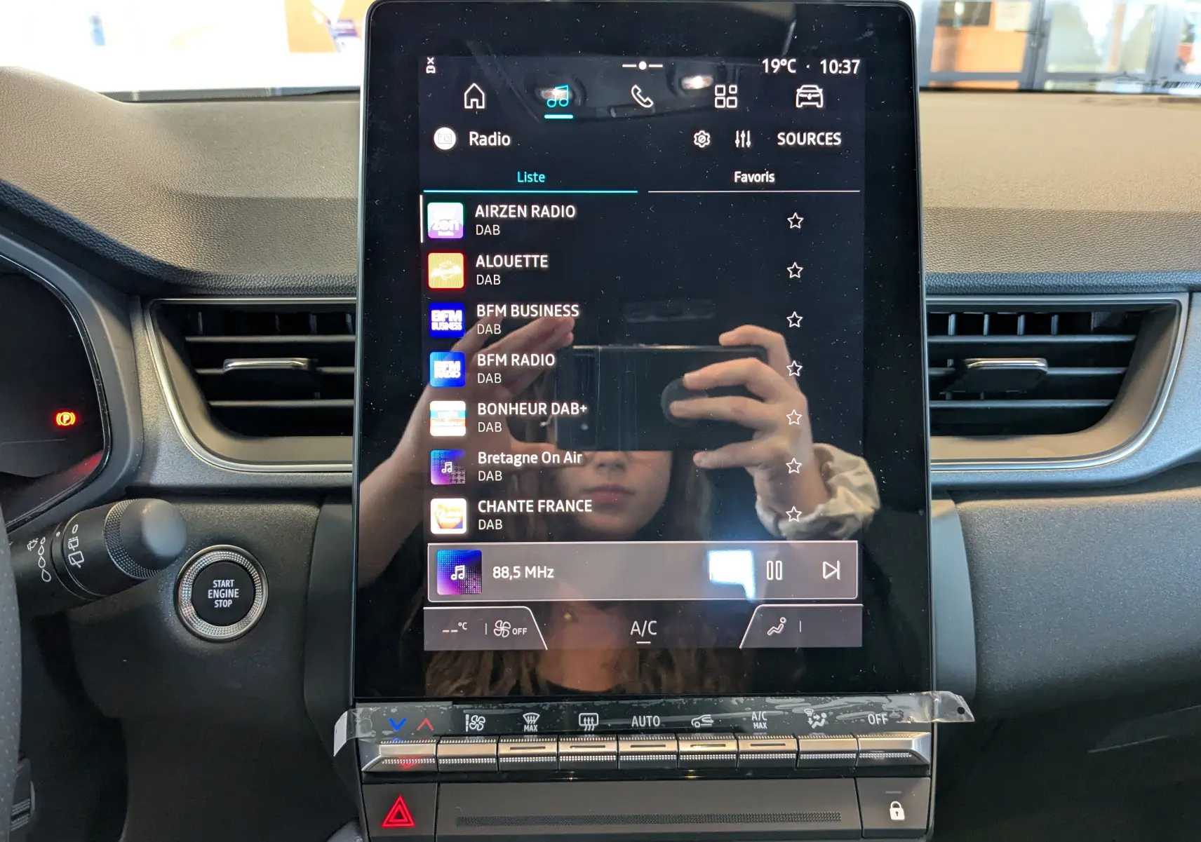 Écran tactile vertical central du tableau de bord du Renault Captur 2025, avec commandes climatisation et démarrage moteur.