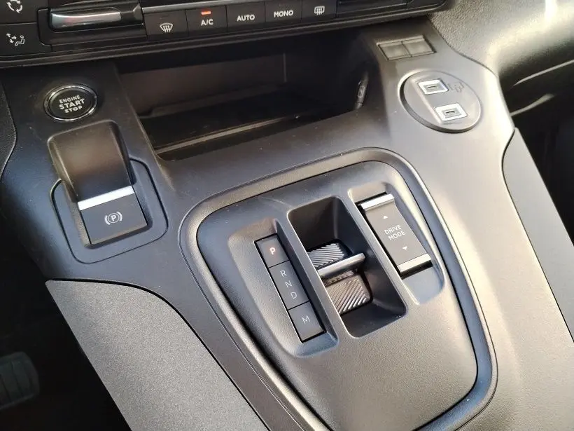 Gros plan sur la console centrale noire du Peugeot Rifter 2025, avec levier de vitesses automatique et bouton start/stop.