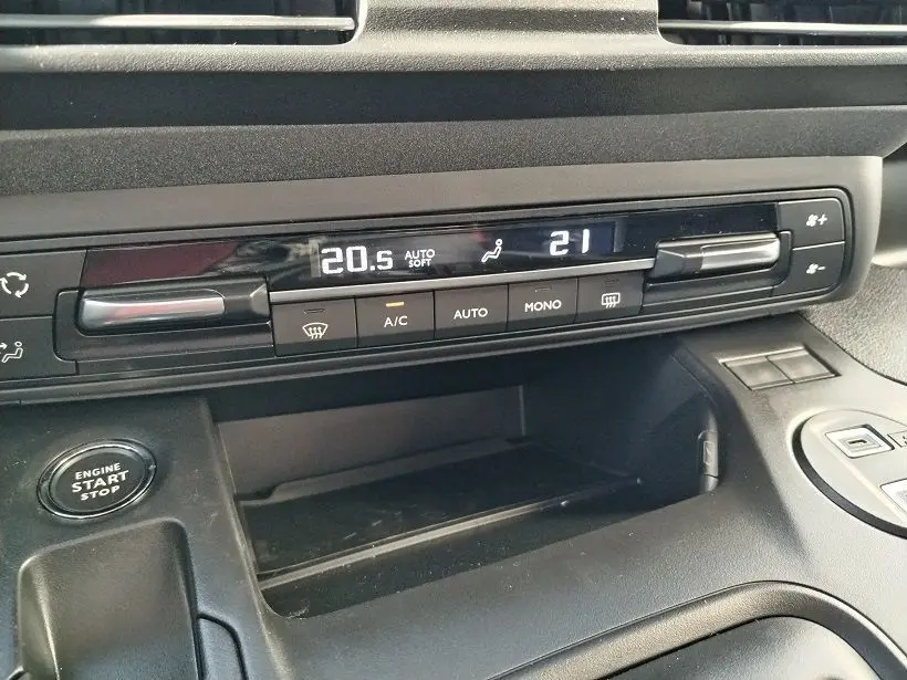 Détail de la console centrale du Peugeot Rifter 2025, affichage digital de la climatisation et bouton start/stop visible.