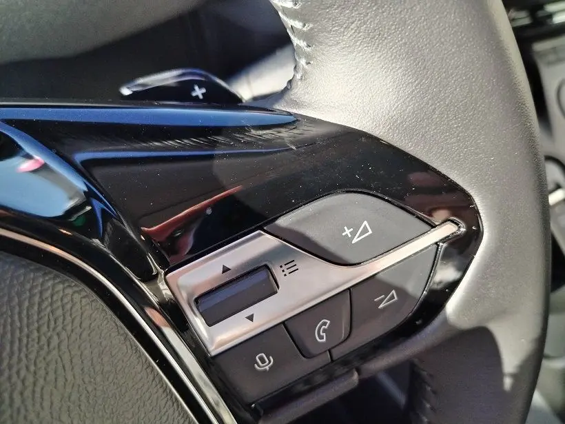 Gros plan sur les commandes multifonctions noires et argentées du volant du Peugeot Rifter 2025, côté gauche.