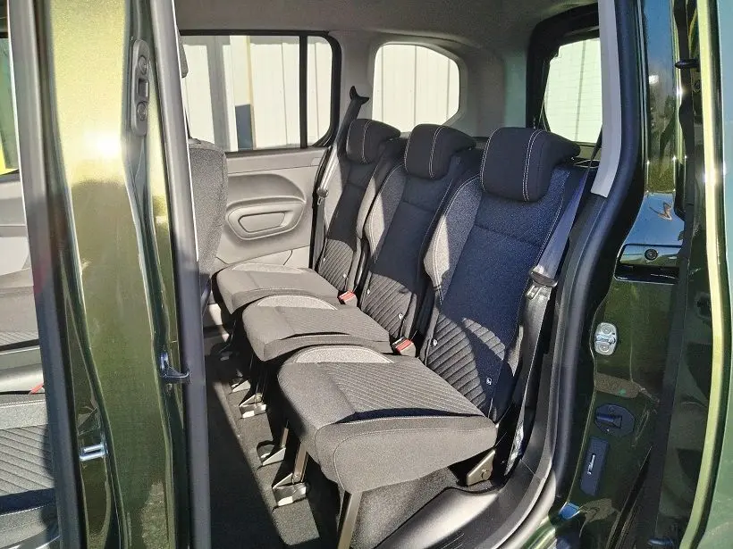 Vue intérieure côté droit sur les sièges arrière noirs du Peugeot Rifter 2025 en Srikka Green avec porte ouverte.