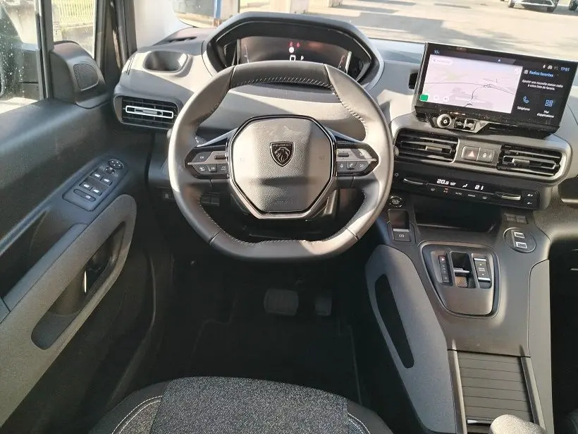 Vue intérieure frontale du poste de conduite du Peugeot Rifter 2025, avec volant compact et écran tactile central.
