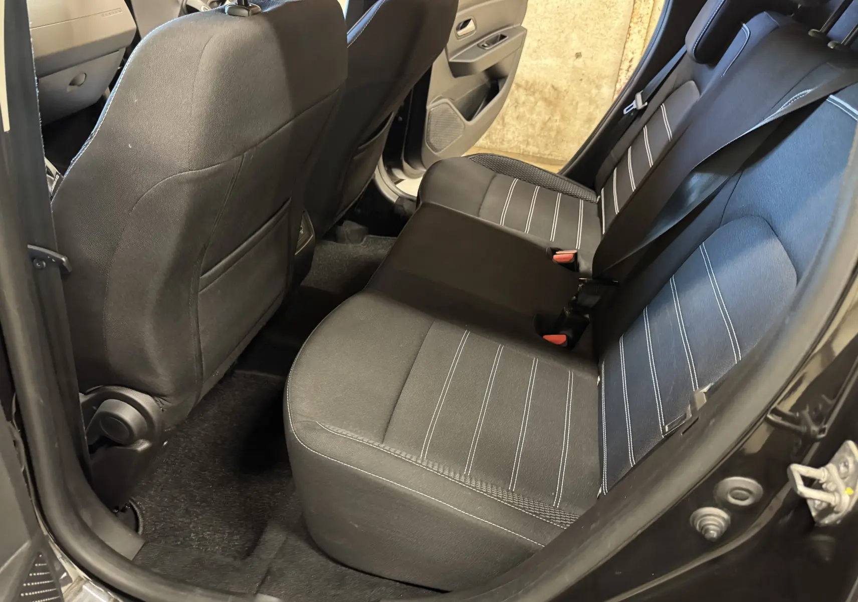 Vue intérieure côté droit des sièges arrière noirs avec surpiqûres blanches du Dacia Duster 2022 version Prestige.