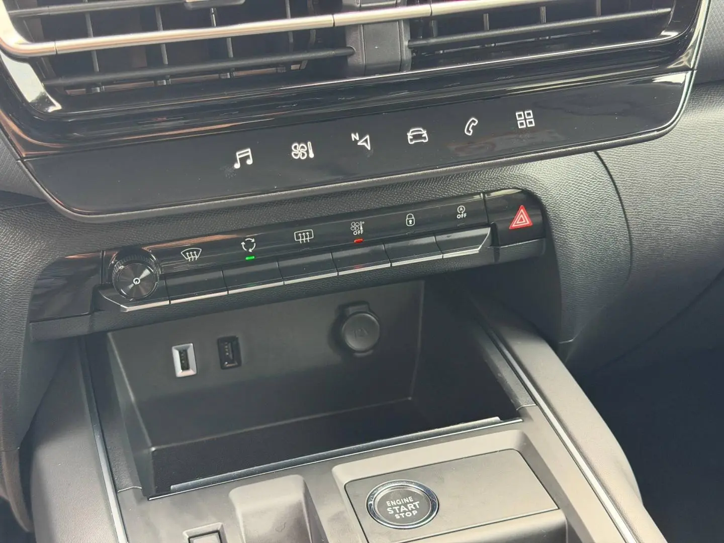 Vue rapprochée de la console centrale noire du Citroën C5 Aircross 2025 avec boutons de commande et prises USB visibles.