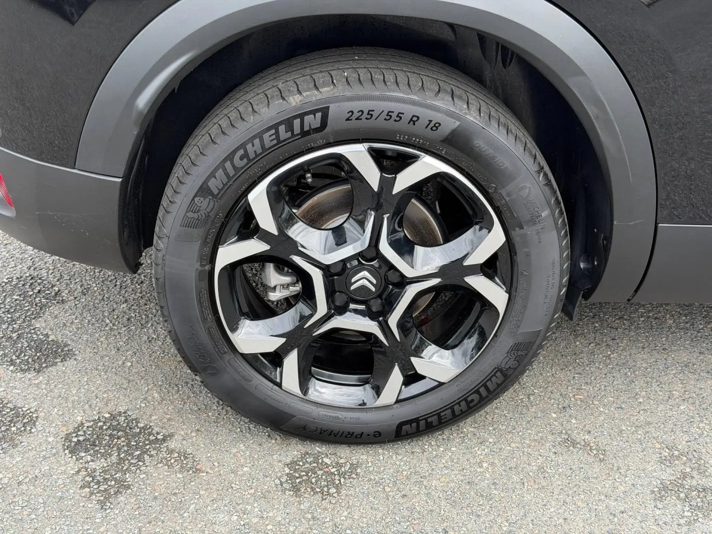Gros plan sur la roue arrière droite noire Perla Nera du Citroën C5 Aircross avec jante alu bicolore et logo Citroën central.