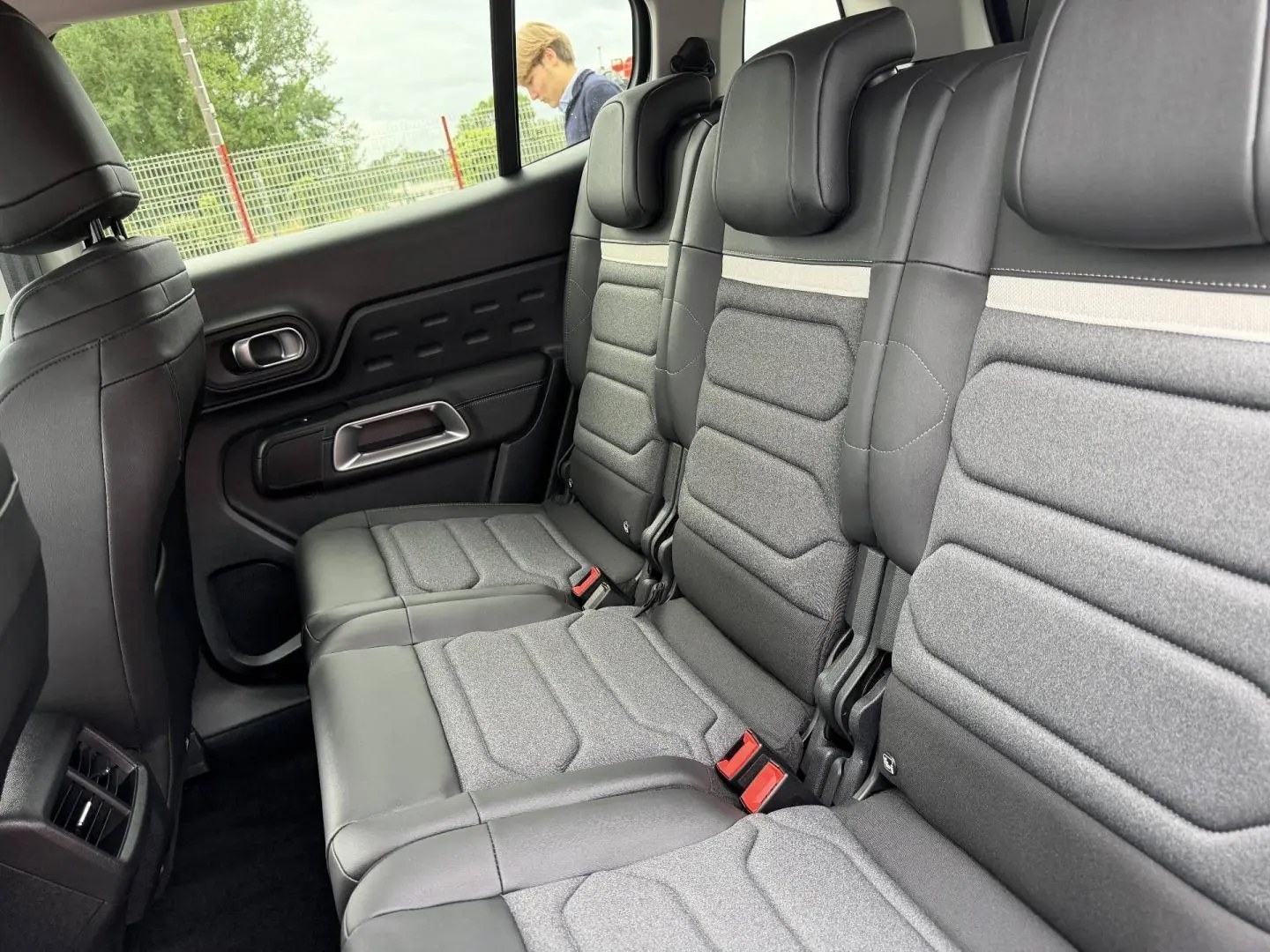 Vue latérale des trois sièges individuels arrière en tissu gris et cuir noir du Citroën C5 Aircross 2025.