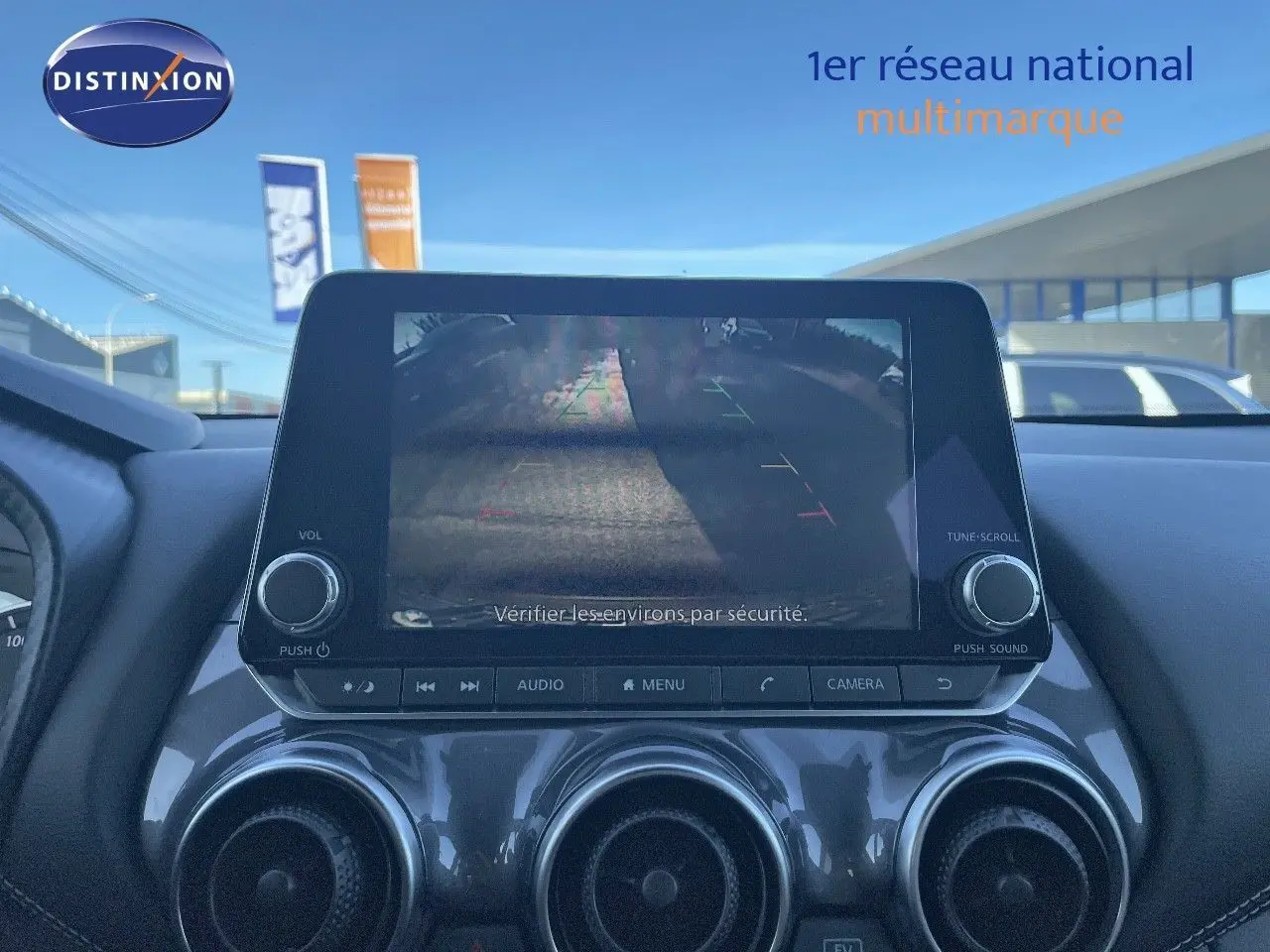 Écran central affichant la caméra de recul du Nissan Juke 2024, tableau de bord en finition noire brillante.