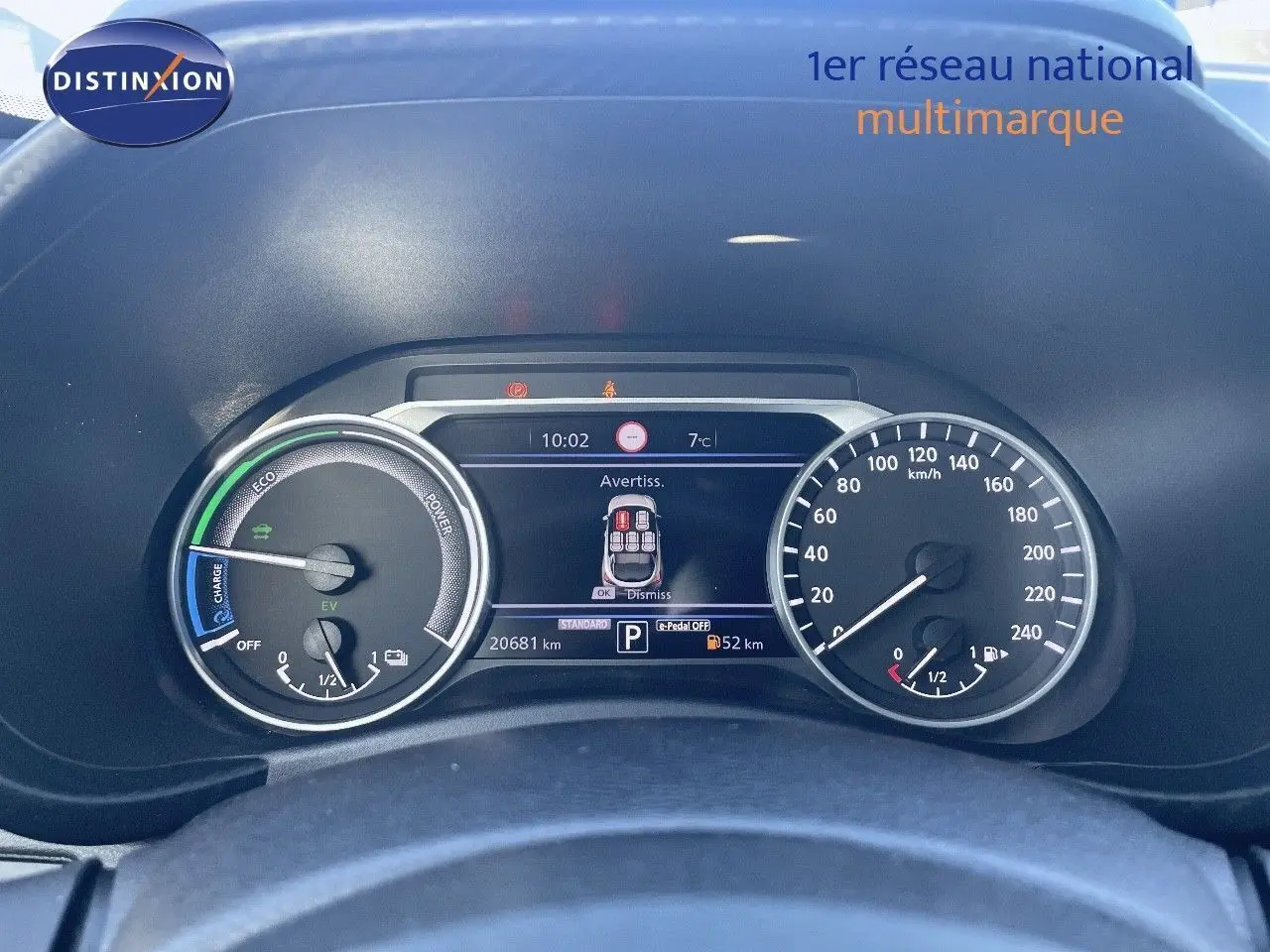 Tableau de bord du Nissan Juke gris squale métal 2024, affichage numérique et compteurs analogiques vus de face.