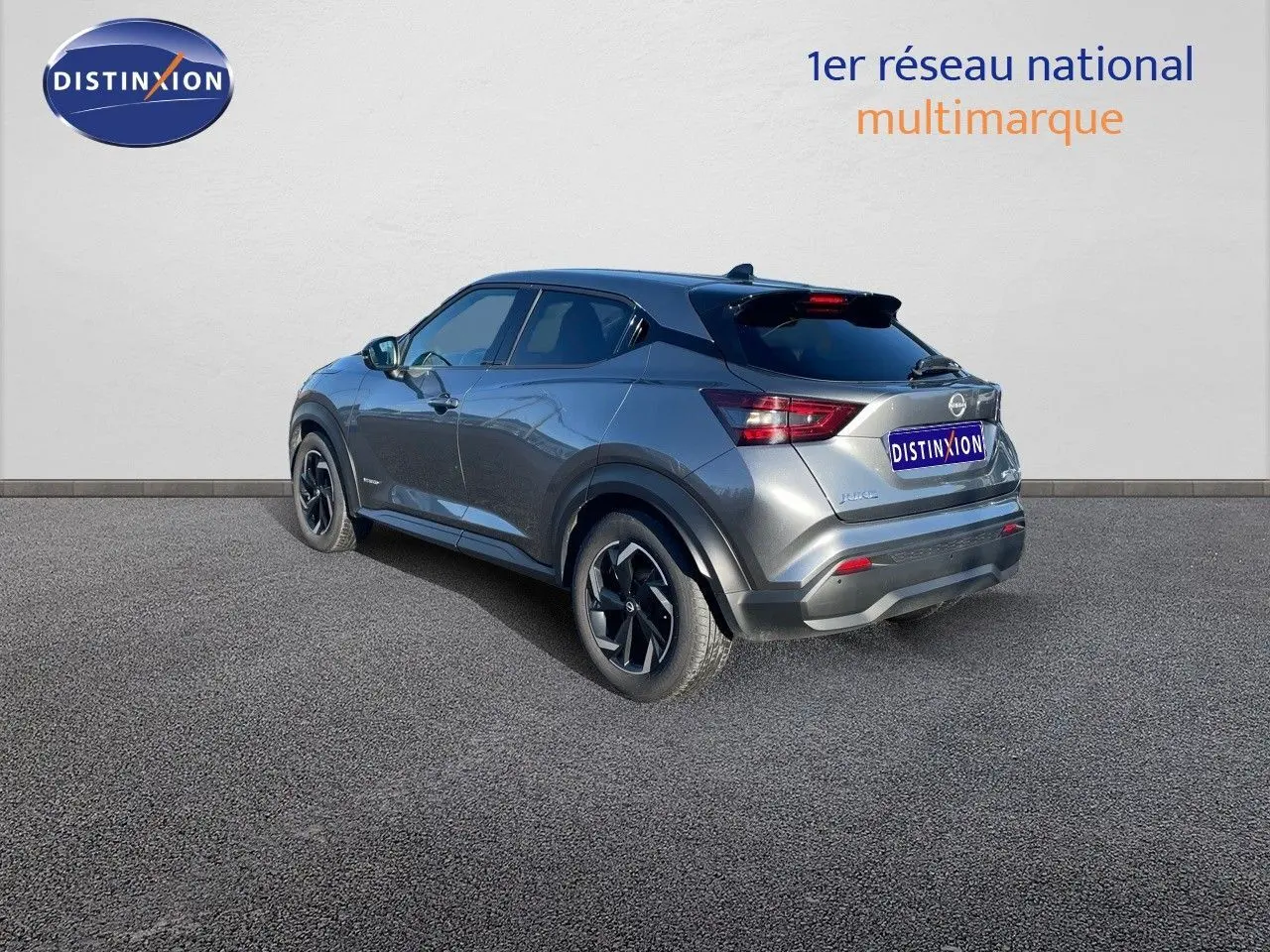 Nissan Juke gris squale métal vu en 3/4 arrière droit, soulignant ses lignes modernes et ses jantes noires biton.