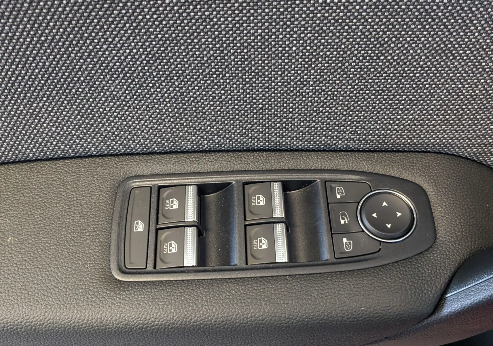 Panneau de commandes des vitres et rétroviseurs côté conducteur du Renault Captur E-Tech 2025, finition tissu gris.