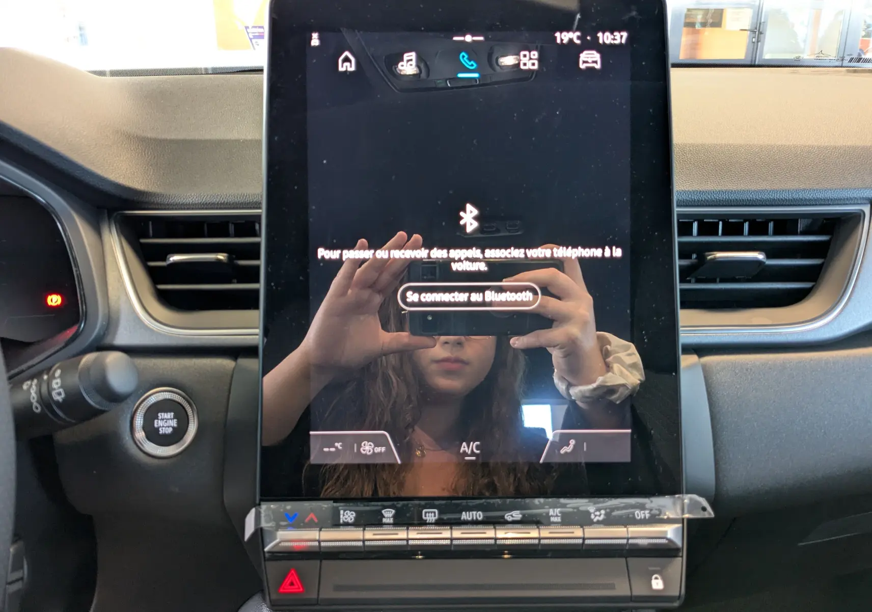 Écran tactile central vertical du tableau de bord du Renault Captur 2025 avec commandes climatisation et démarrage sans clé.