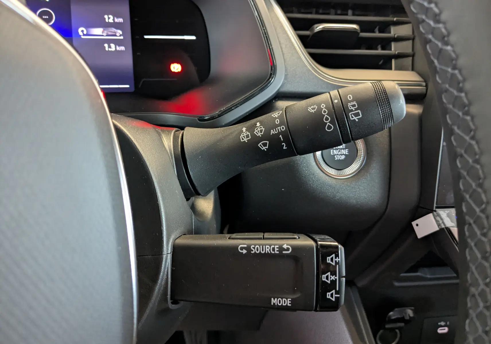 Gros plan sur les commandes au volant et le bouton start/stop du tableau de bord du Renault Captur E-Tech 2025.