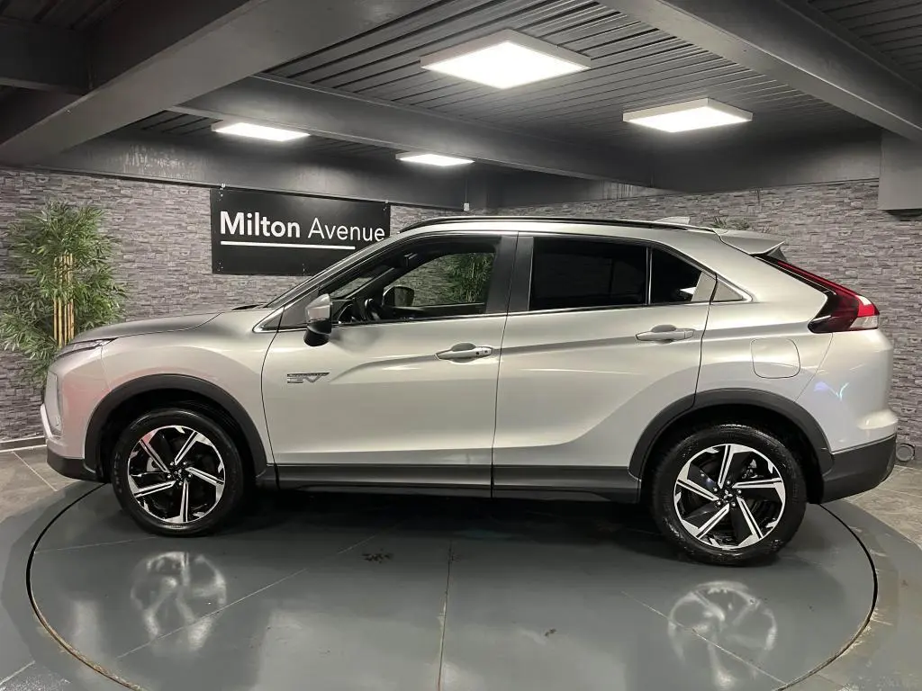 Profil côté gauche du Mitsubishi Eclipse Cross gris métallisé 2022 avec jantes alliage bi-ton et vitres surteintées.