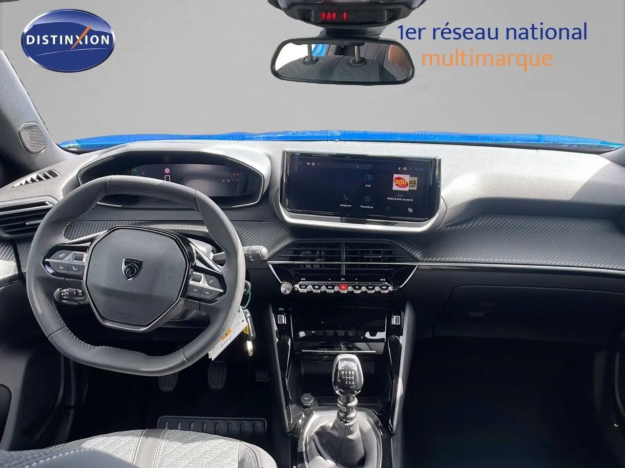 Intérieur du Peugeot 2008 2024 bleu Vertigo, vue frontale sur le tableau de bord et la boîte manuelle.