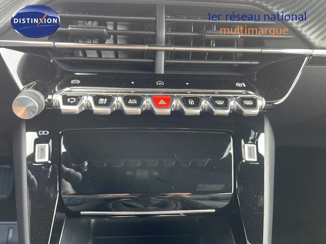 Vue rapprochée de la console centrale noire brillante du Peugeot 2008 2024 avec boutons de commande et écran tactile éteint.