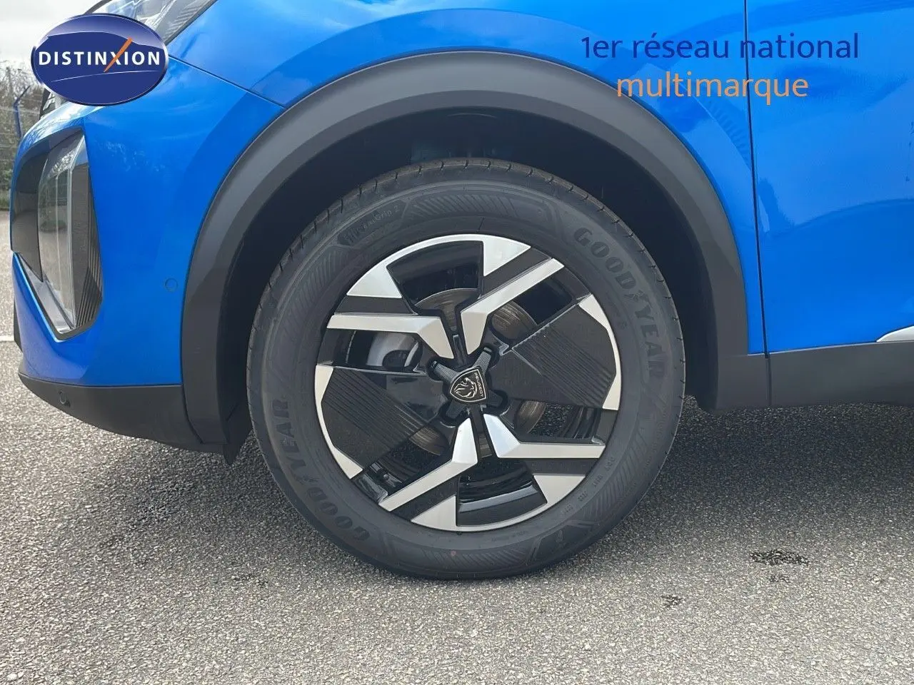 Gros plan sur la roue avant gauche d'un Peugeot 2008 bleu Vertigo Métal avec jante noire et argentée.