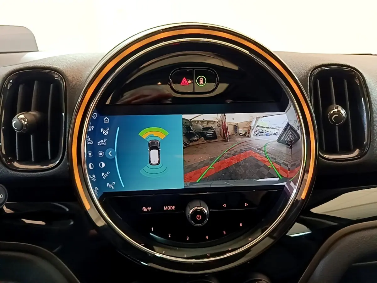 Écran central circulaire du tableau de bord MINI Countryman Cooper SE, affichant la caméra de recul et capteurs de stationnement.