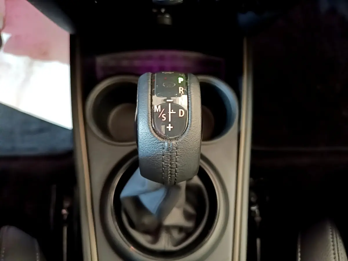 Le levier de vitesses automatique en cuir noir vu de dessus dans le MINI Countryman vert hybride 2023.