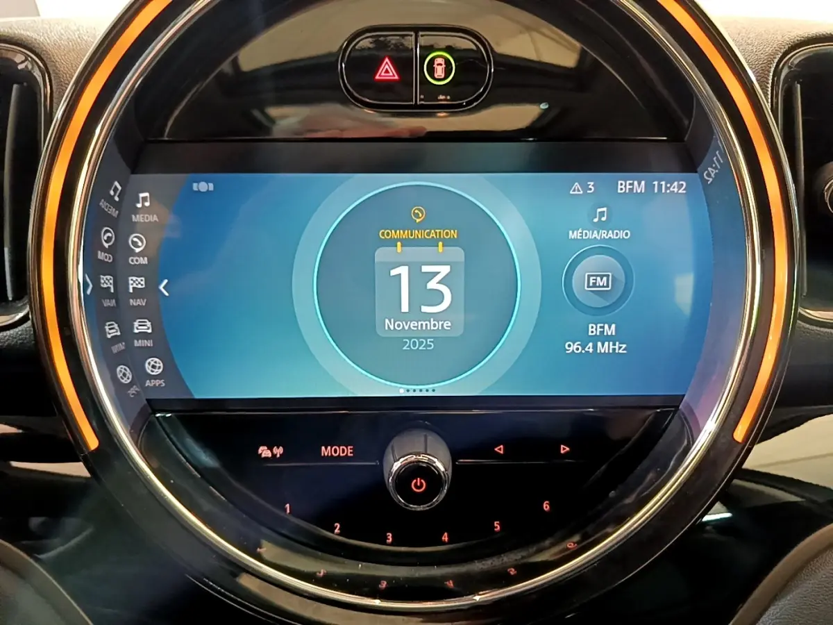 Écran tactile central circulaire du tableau de bord de la MINI Countryman Cooper SE vert, affichant la date et radio FM.
