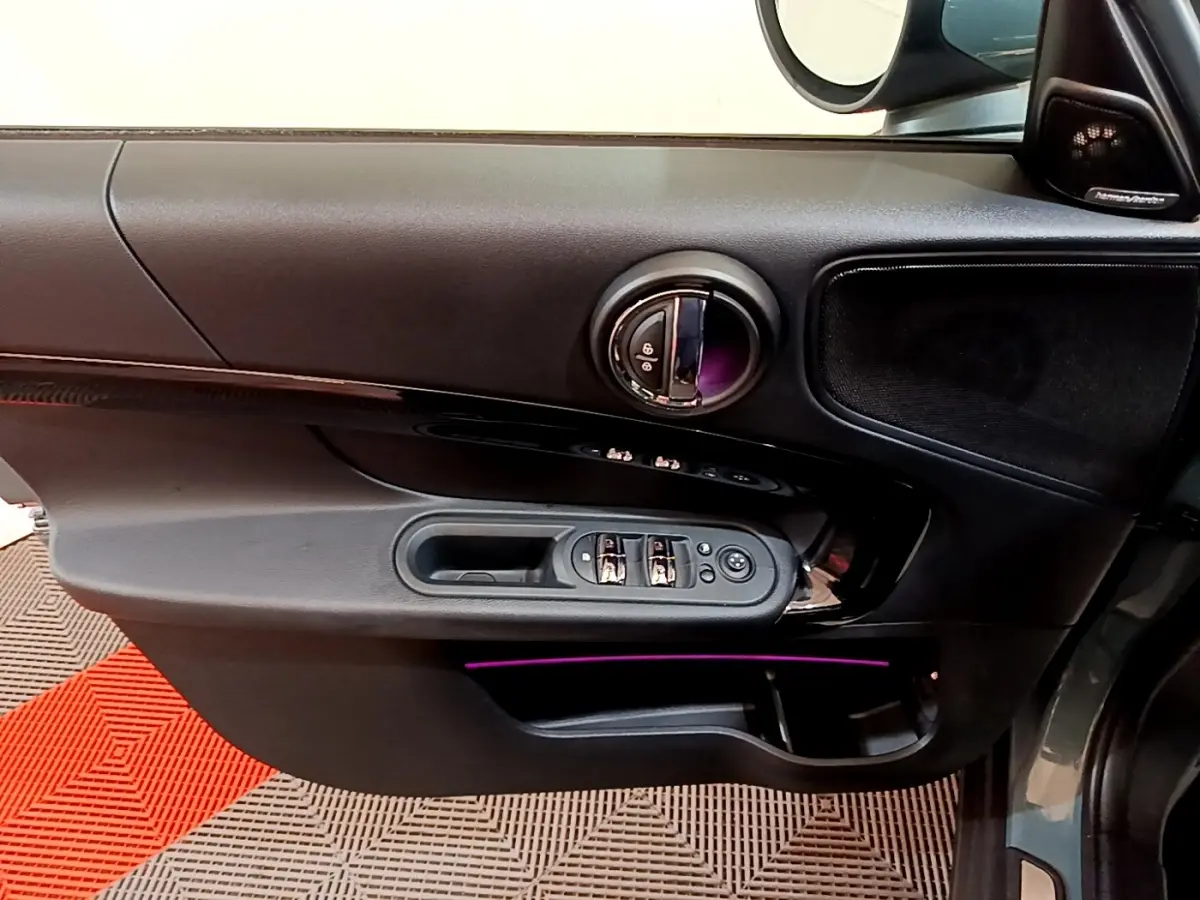 Porte côté conducteur noire du MINI Countryman Cooper SE 2023 avec éclairage d'ambiance violet et commandes électriques.
