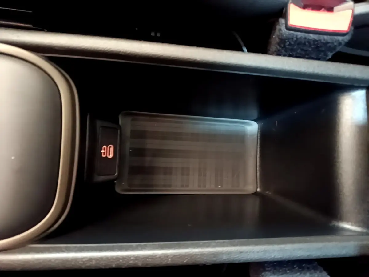 Zone de recharge par induction noire dans la console centrale du MINI COUNTRYMAN Cooper SE 2023, vue de dessus.