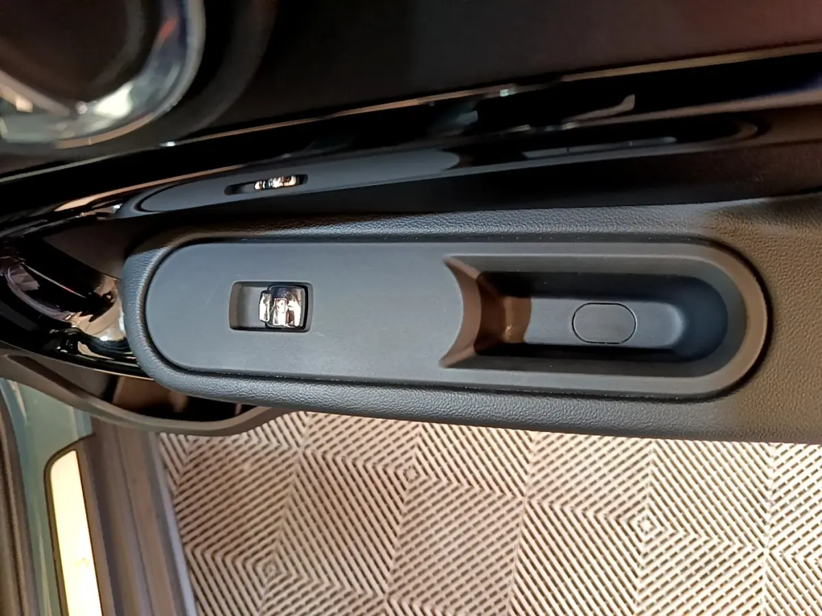 Poignée intérieure de porte côté gauche du MINI Countryman vert, avec commande de verrouillage visible.