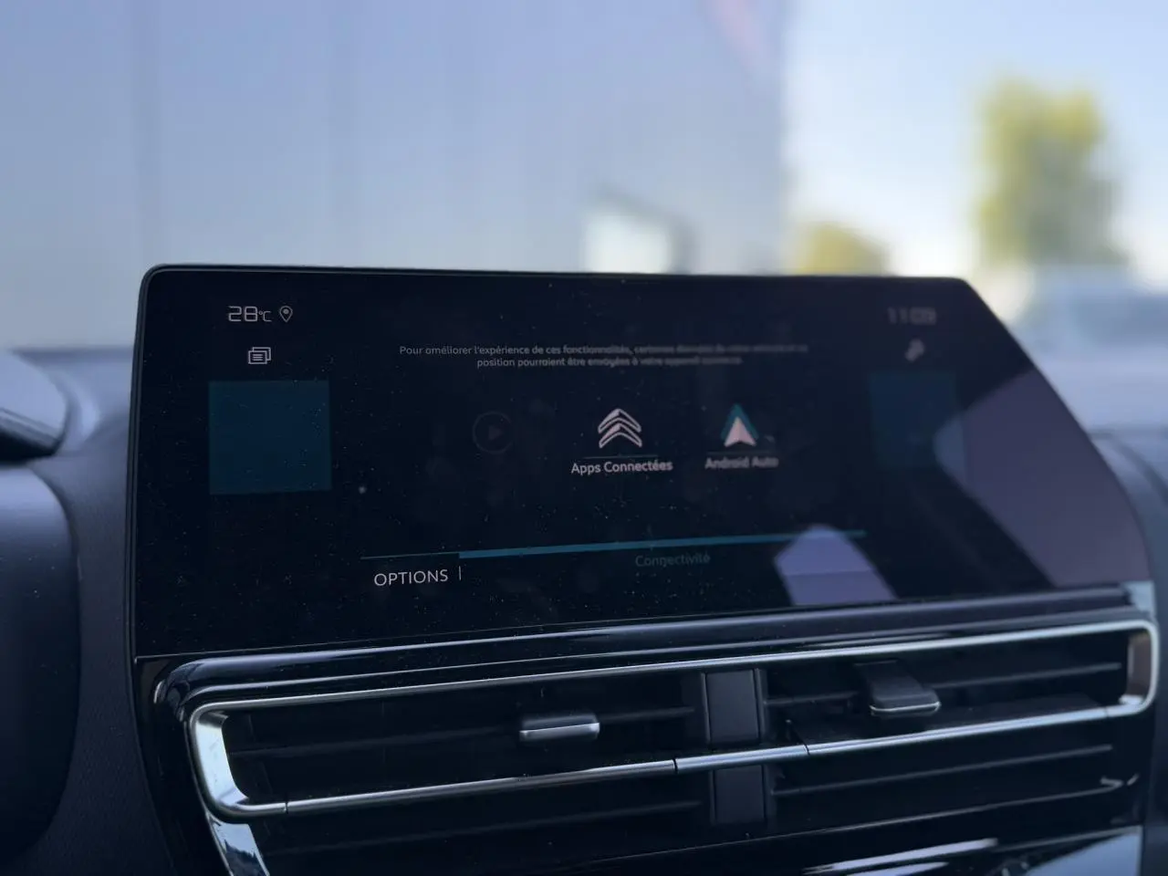 Gros plan sur l'écran tactile central et les aérateurs du tableau de bord du Citroën C5 Aircross Hybrid gris Platinium.