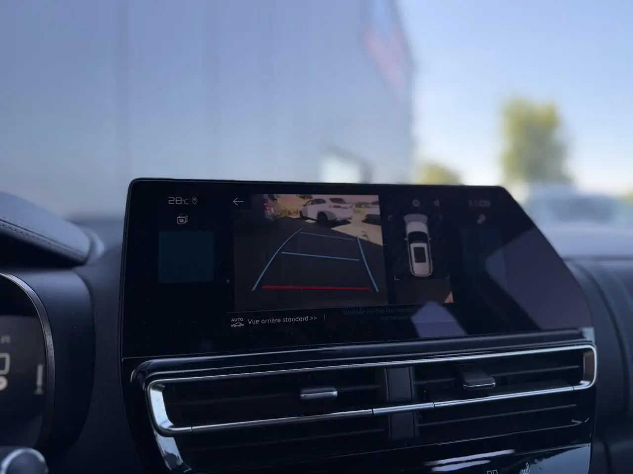 Écran tactile intérieur montrant la caméra de recul du Citroën C5 Aircross Hybrid gris Platinium, vue avant du tableau de bord.