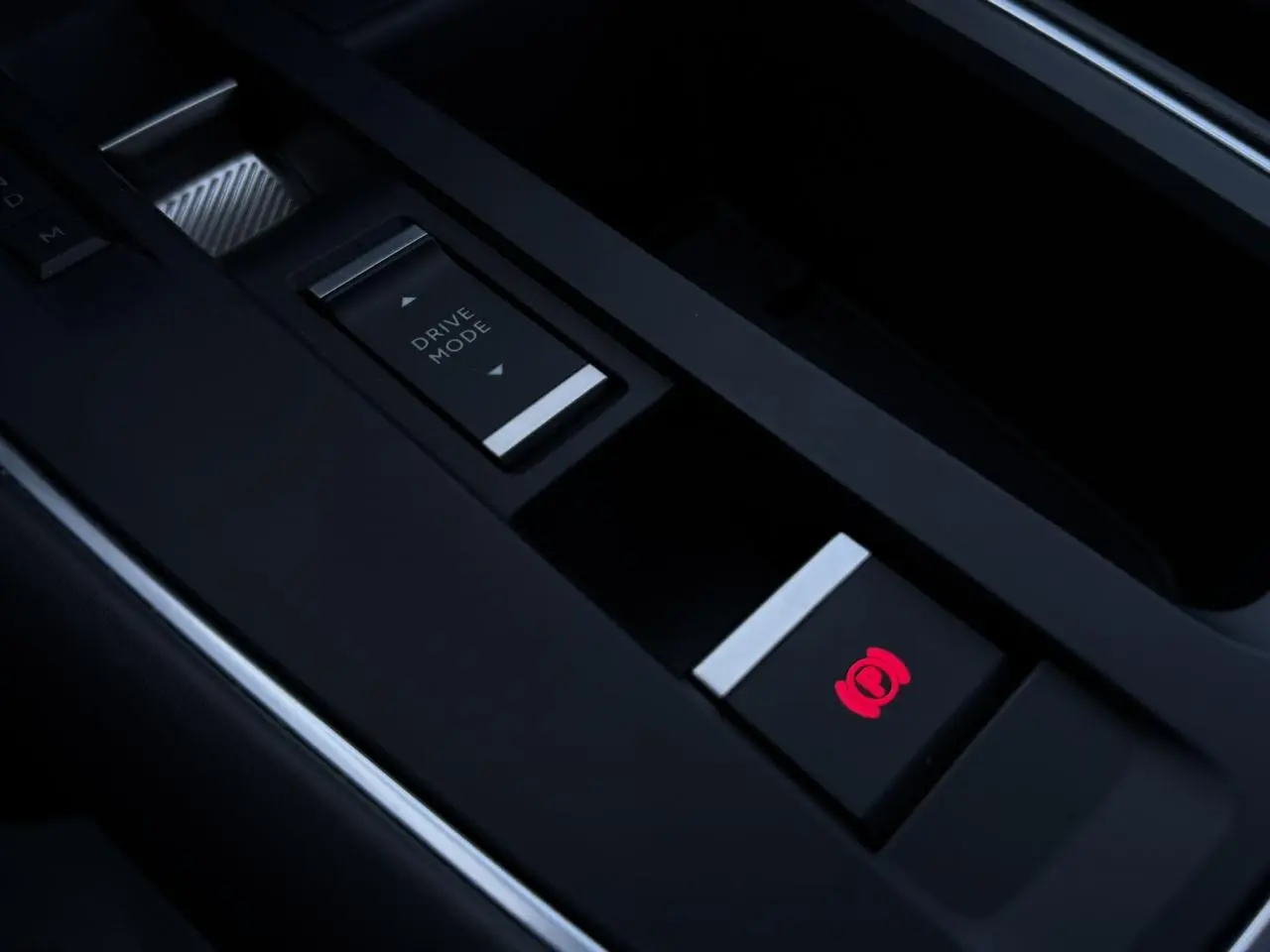 Gros plan sur la console centrale noire du Citroën C5 Aircross Hybrid avec bouton frein électrique rouge et commande Drive Mode.