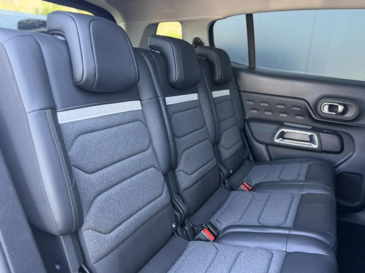 Vue latérale des trois sièges arrière indépendants en tissu et cuir noir du Citroën C5 Aircross Hybrid 2025.