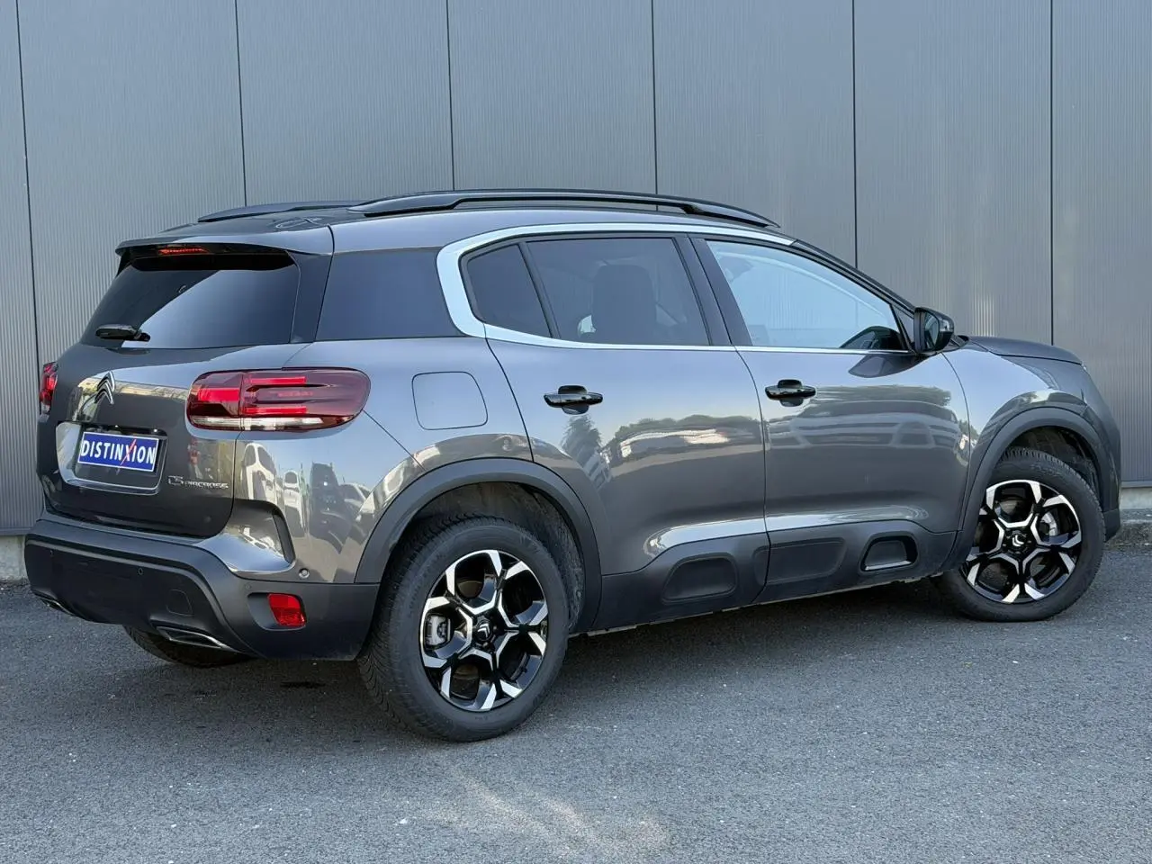 Vue 3/4 arrière droite du Citroën C5 Aircross Hybrid gris Platinium avec jantes alliage bi-ton et vitres surteintées.