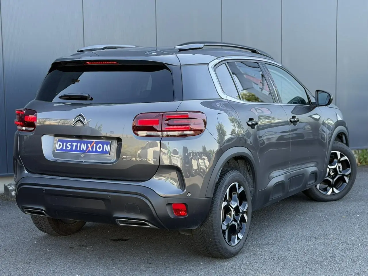 Vue 3/4 arrière droite d'un Citroën C5 Aircross Hybrid gris Platinium avec jantes diamantées et hayon électrique.