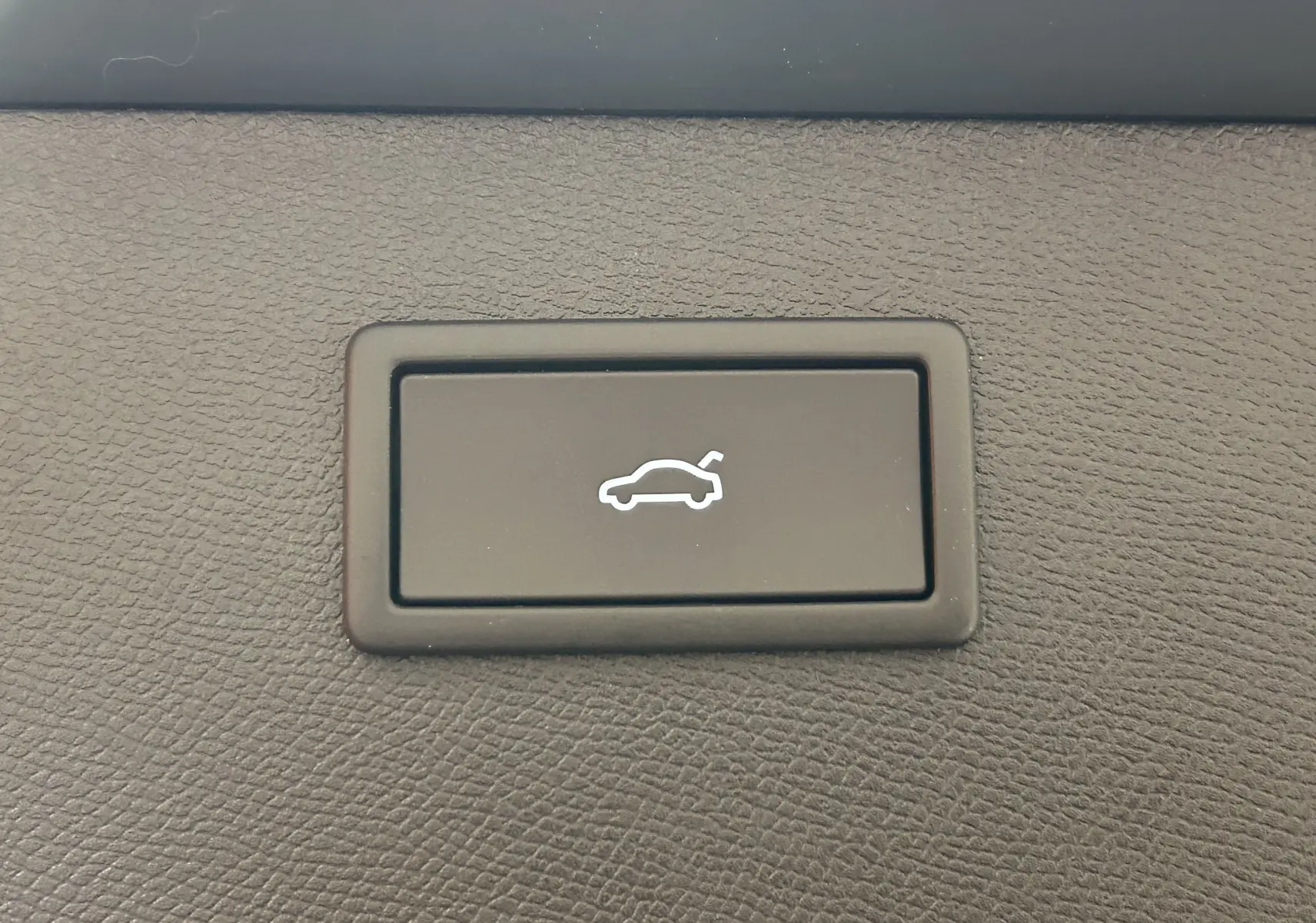 Bouton noir avec icône blanche d'ouverture de hayon, détail intérieur du CUPRA Formentor 2026 bleu Fjord Metal