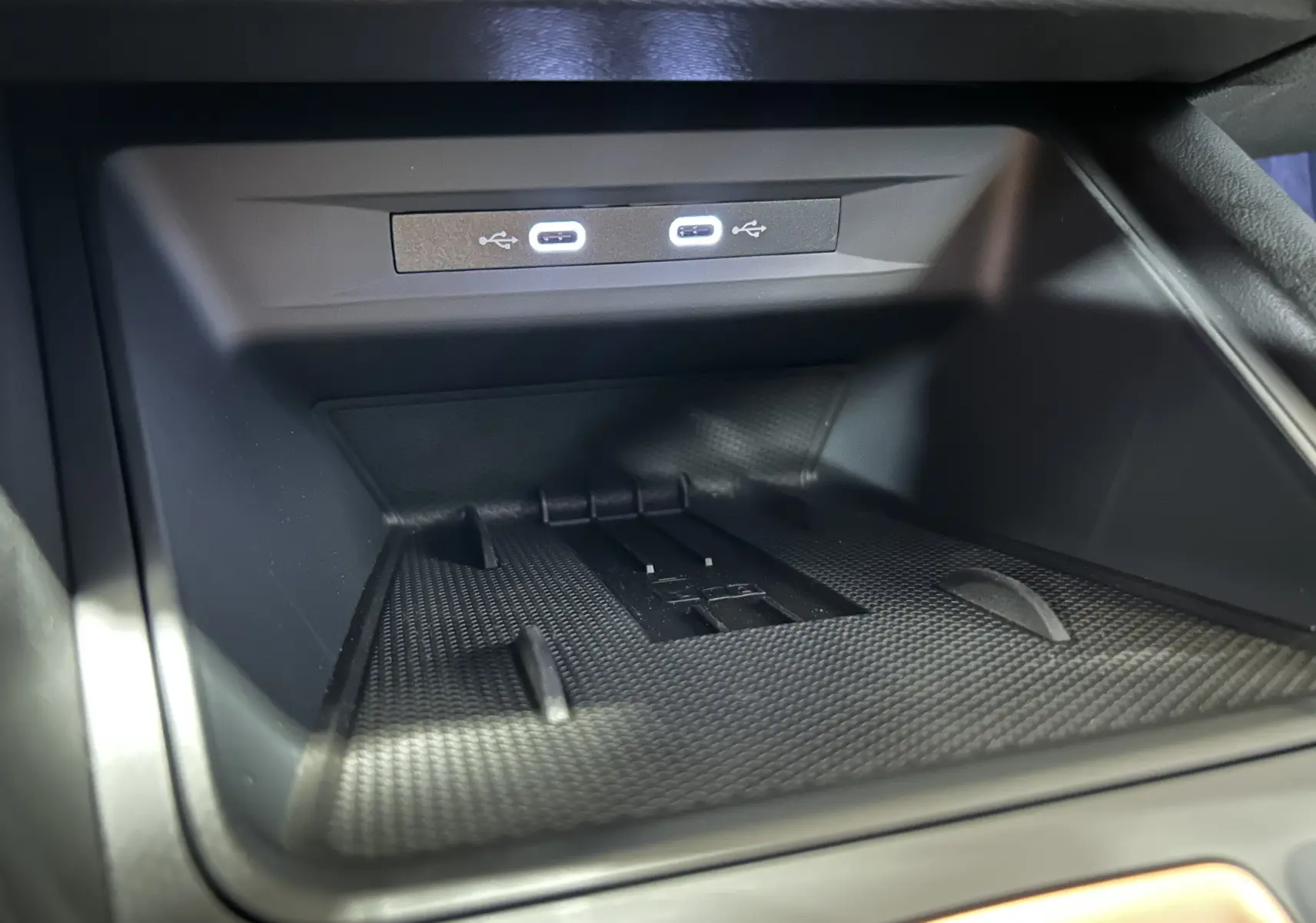 Gros plan sur la console centrale avec deux ports USB-C illuminés dans l'habitacle noir du CUPRA Formentor.
